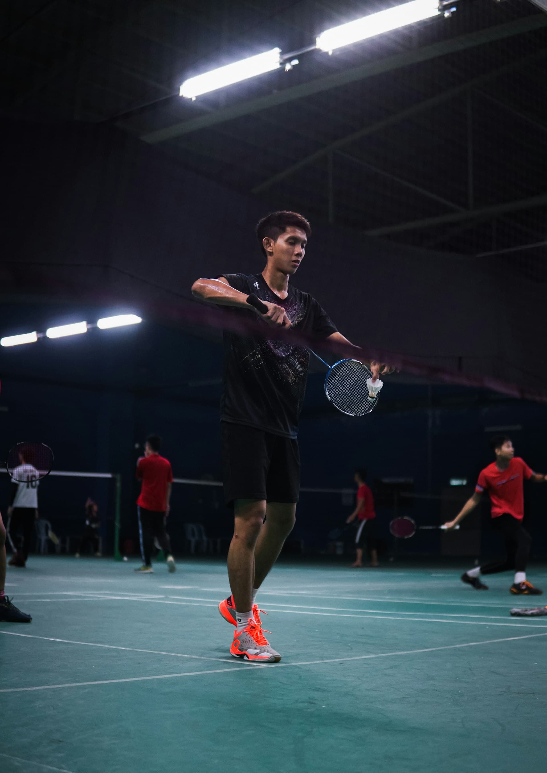 Badminton players training in indoor court